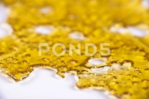 A piece of cannabis oil concentrate aka shatter isolated on white Stock Photos
