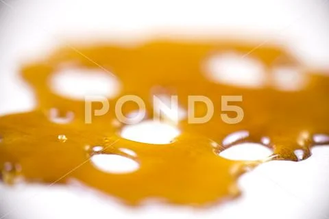 Piece of cannabis oil concentrate aka shatter isolated against white backgrou Stock Photos