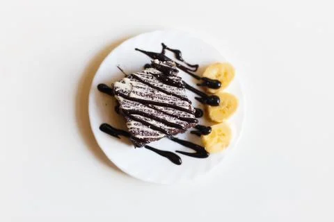 The piece of the chocolade cake with babanas decorated with powder and chocolade Foto stock