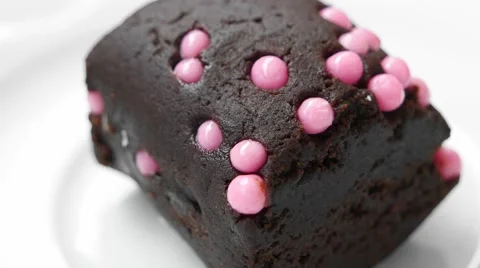 Piece of chocolate cake with pink balls decoration closeup Stock Footage 54226880