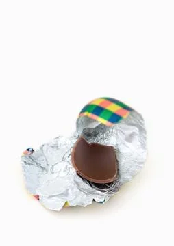 Piece of chocolate egg on wrapper Stock Photos