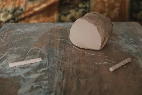 Piece of clay cut with string lying on wooden table prepared for pottery whee Stock Photos