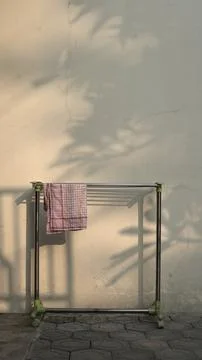 A piece of cloth with a red checkered pattern is dried on a clothesline. Stock Photos