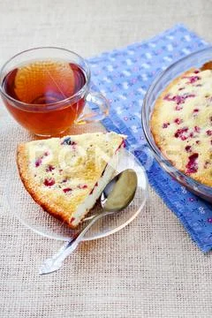 Piece of cowberry pie on glass plate and cup of tea Stock Photos