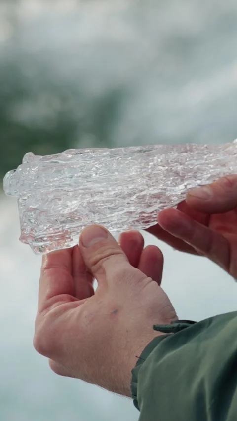 A piece of crystal clear ice in the hands of a man. Stock Footage 344021794