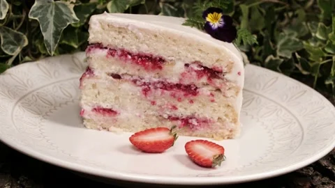 Piece of delicious sponge cake with large strawberries on top. A biscuit piece o Stock Footage 145750979