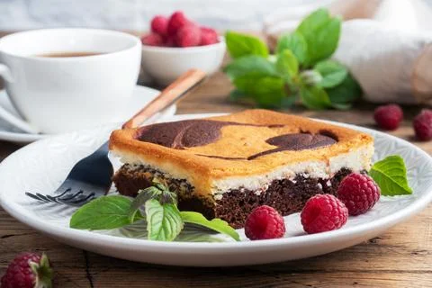 A piece of double-layer cake on a plate of chocolate brownies and curd chee.. Stock-Fotos