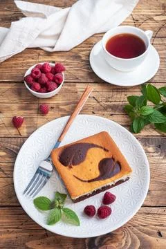 A piece of double-layer cake on a plate of chocolate brownies and curd chee.. Foto stock