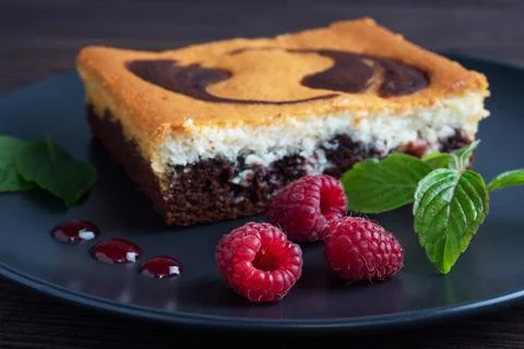 A piece of double-layer cake on a plate of chocolate brownies and curd chee.. Stock-Fotos