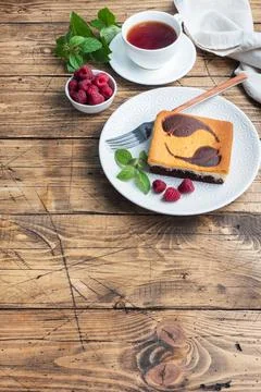 A piece of double-layer cake on a plate of chocolate brownies and curd chee.. Foto stock