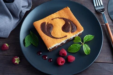 A piece of double-layer cake on a plate of chocolate brownies and curd chee.. Stock-Fotos