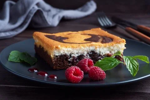 A piece of double-layer cake on a plate of chocolate brownies and curd chee.. Stock-Fotos