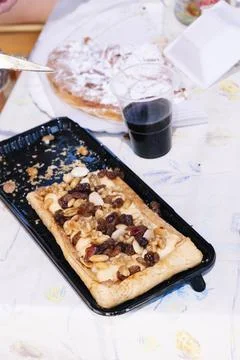 Piece of dried fruit cake on top of a table with more food. Stock Photos