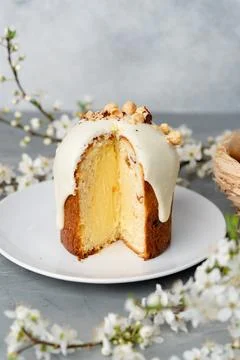 Piece of Easter cake on plate decorated with spring flower branches Stock Photos