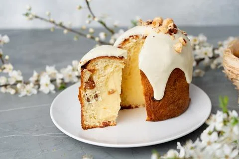 Piece of Easter cake on plate decorated with spring flower branches Stock Photos