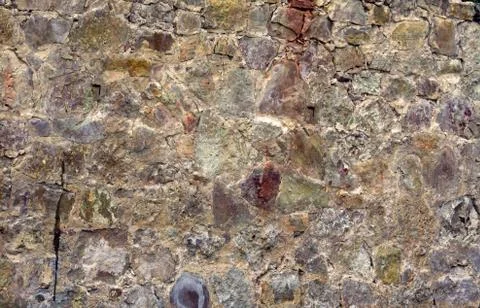 A piece of a flat stone wall, an old cracked surface consists of stones Stock Photos