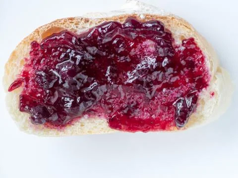 Piece of french bread with cherry jam Stock Photos
