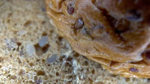 A piece of fresh rye bread with flax seeds in close-up. Macro food. Stock Photos