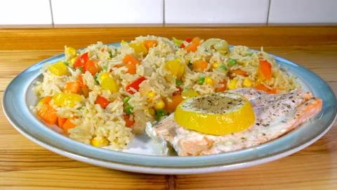 Piece of freshly cooked salmon with vegetable rice on a plate. Stock Footage 200879463
