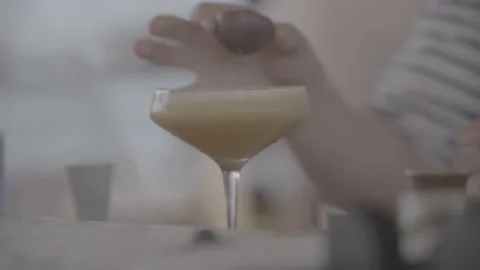 Piece of fruit being put into orange martini in a bar Stock Footage 201135723