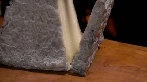 Piece of goat cheese falling on the wooden board Stock Footage