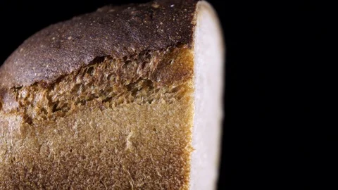 Piece of gray bread on a dark background macro slow motion Stock Footage 100158982