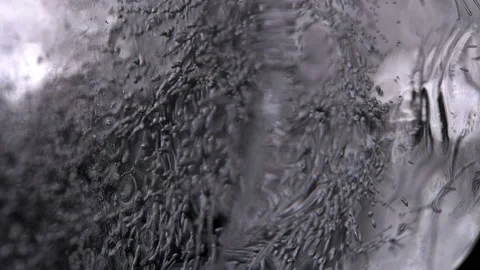 A piece of ice with bubbles slowly rotating, close up Stock Footage 86332673