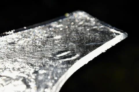 A piece of ice on a dark background. Stock Photos