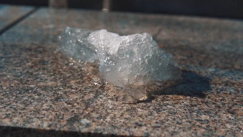 Piece of ice melts under hot sunbeams. Stock Footage 106376684