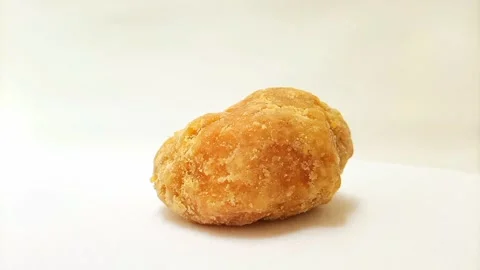 A Piece of Jaggery or Gur isolated rotating on white background, close up. .. Stock Footage 282583728