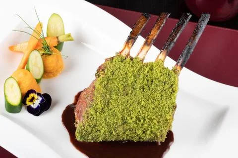 Piece of lamb rack with bone roasted with green herb, bread, sweet potatoes p Stock Photos