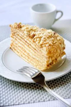 Piece of layer cake with custard and walnuts on a plate Stock Photos