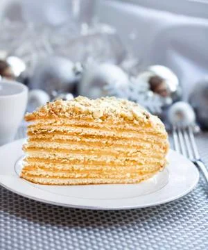 Piece of layer cake with custard and walnuts on a plate Stock Photos