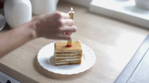 A piece of layered cake with a candle. Congratulation with a pie with candles Stock Footage 229856707