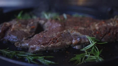 A piece of meat is cooked in a pan with herbs on top Stock-Footage 297871527