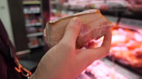 A piece of meat in vacuum packaging in the hands of a customer Stock Footage 297624639