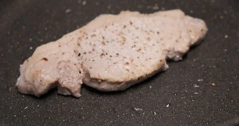 Piece of meat was put in pan, meat on frying surface, spices, roasting, food Stock Footage 120896232