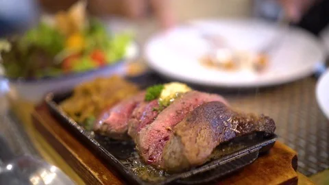 Piece of medium beef steak on hot steel plate, slow motion with smoke Stock-Footage 106374472