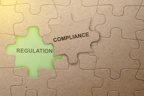 Piece of missing jigsaw puzzle with compliance text Stock Photos