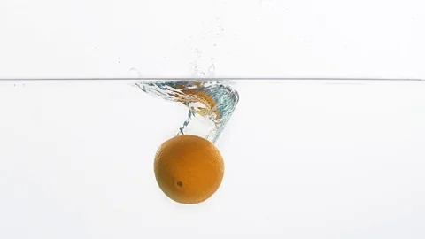 A piece of orange falling into a water Stock Footage 99724372