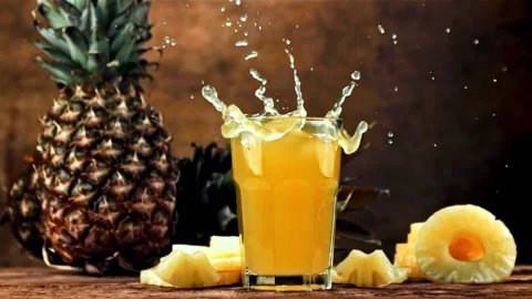 Piece of pineapple falls into pineapple juice. Filmed is slow motion 1000 fps. Stock Footage 225664190