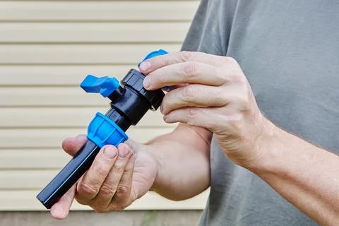 Piece of plastic pipe is inserted into compression threaded clamp of valve Stock Photos