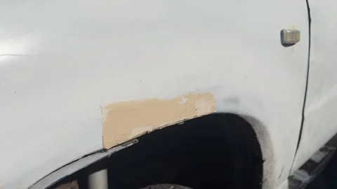 A piece of primer applied to a white car in close-up Stock Footage 280498650