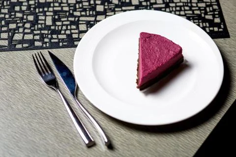 A piece of raspberry cheesecake in white plate served on the table Stock Photos
