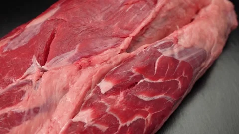 Piece of raw beef meat close up on black background Video stock 147075127