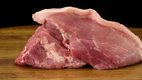 A piece of raw fresh pork meat on a wooden surface Stockbeeldmateriaal 155460403
