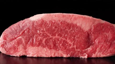 Piece of raw marbled beef close up on black background Vídeos de archivo 147022062