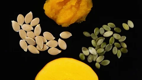 Piece of raw rip pumpkin rotates with squash soup and pepitas. 4K Vídeo Stock 74060911