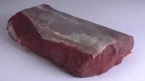 Piece of raw roast beef over white background Stock Footage 56767643