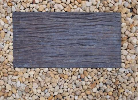 Piece of rectangle wood on pebble as background copy space Stock Photos